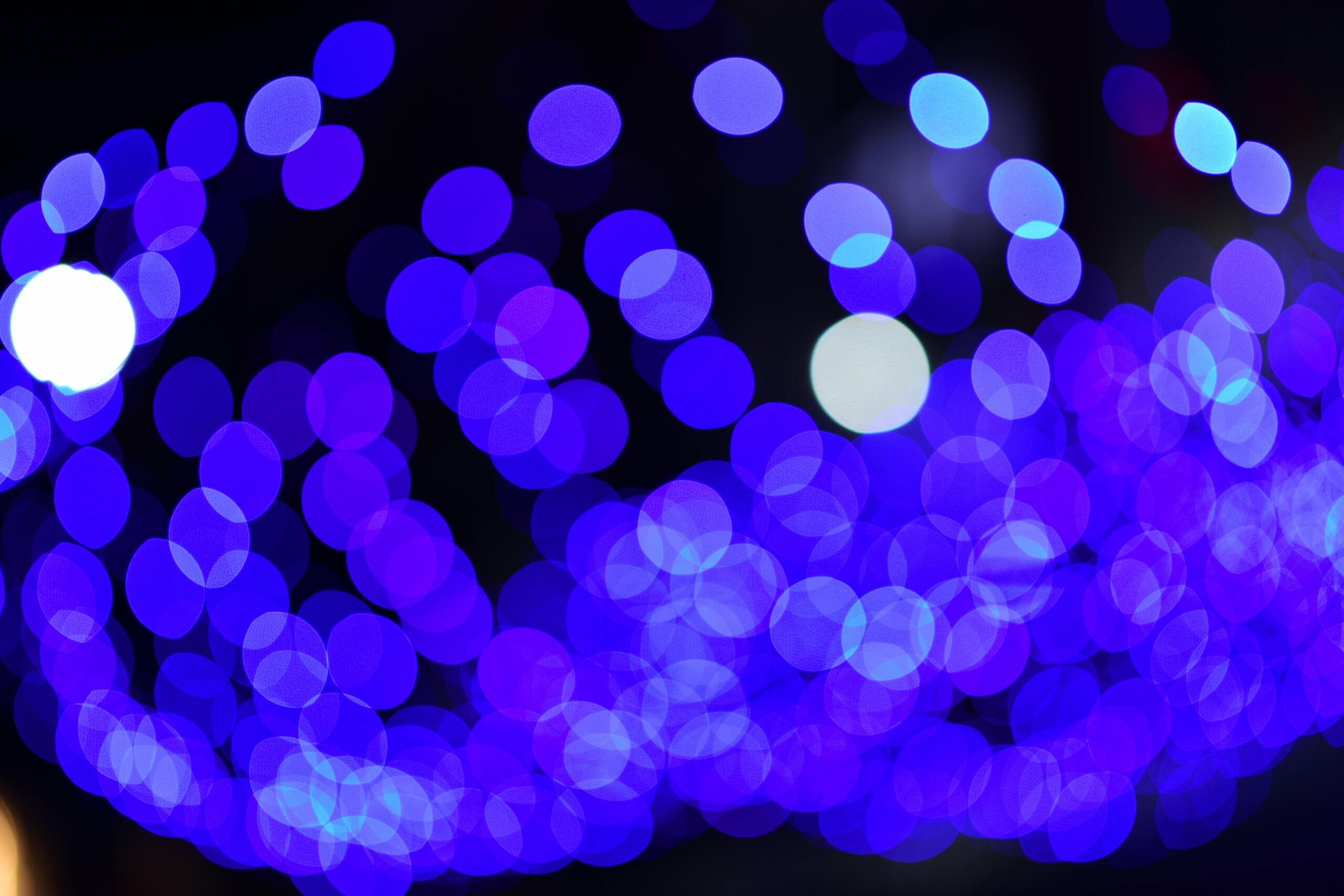 Abstract blue bokeh lights create a vibrant, dreamy night scene.